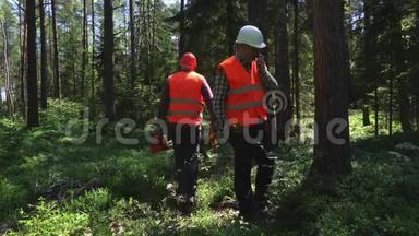 森林管理员和对讲机交谈，并标记树木